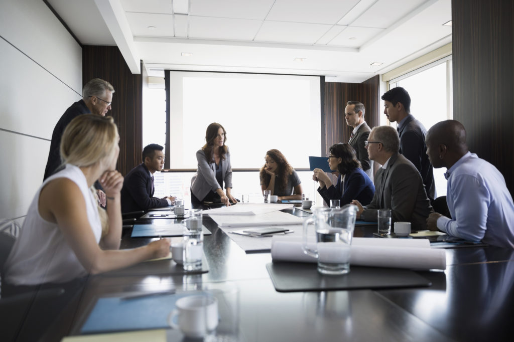 Architects reviewing blueprints in conference room meeting